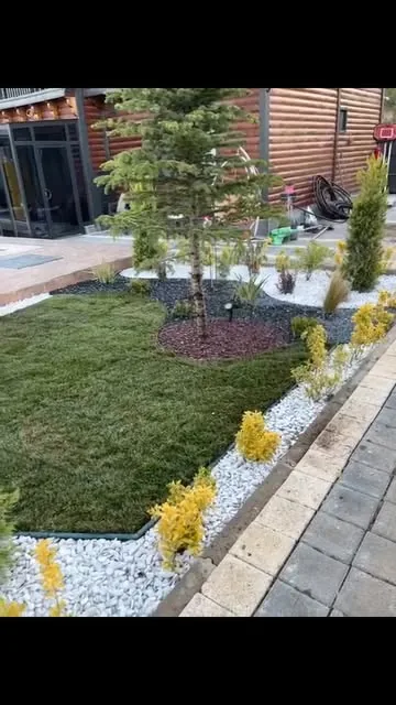 Çim, bordür ve süs bitkileriyle düzenlenmiş villa bahçesi